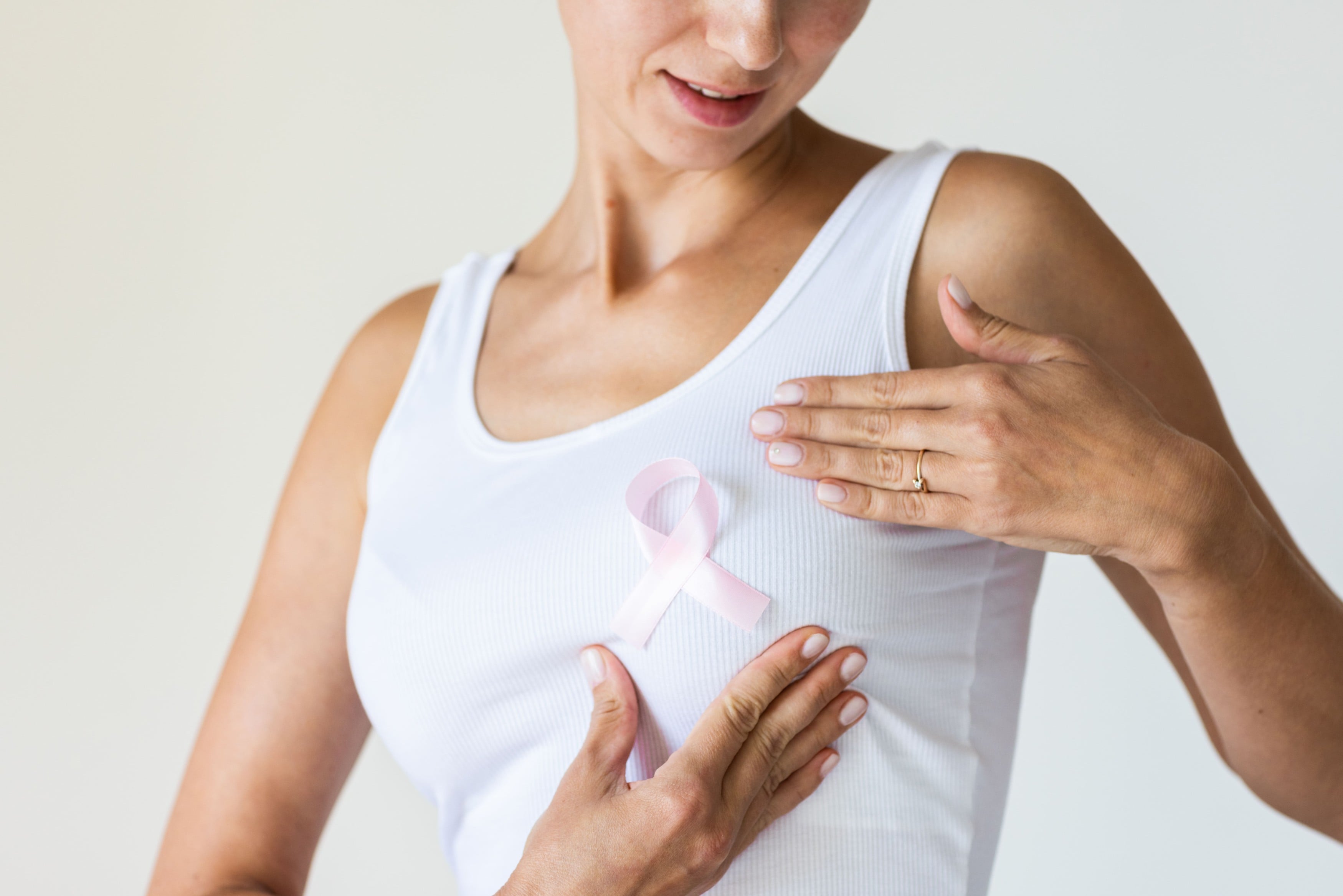 Mulher com laço rosa da campanha contra o câncer