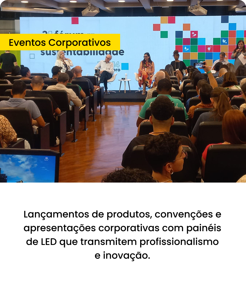 Painel de LED em evento corporativo, com plateia diante do palco