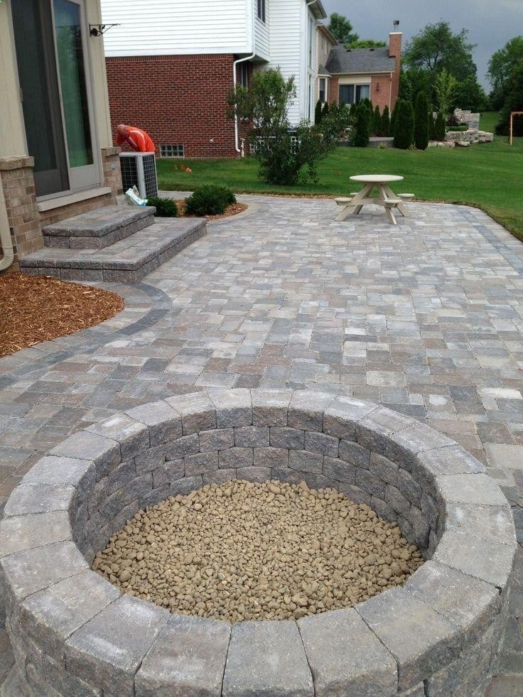 Paver patio with a stone fire pit built by MG Landscaping