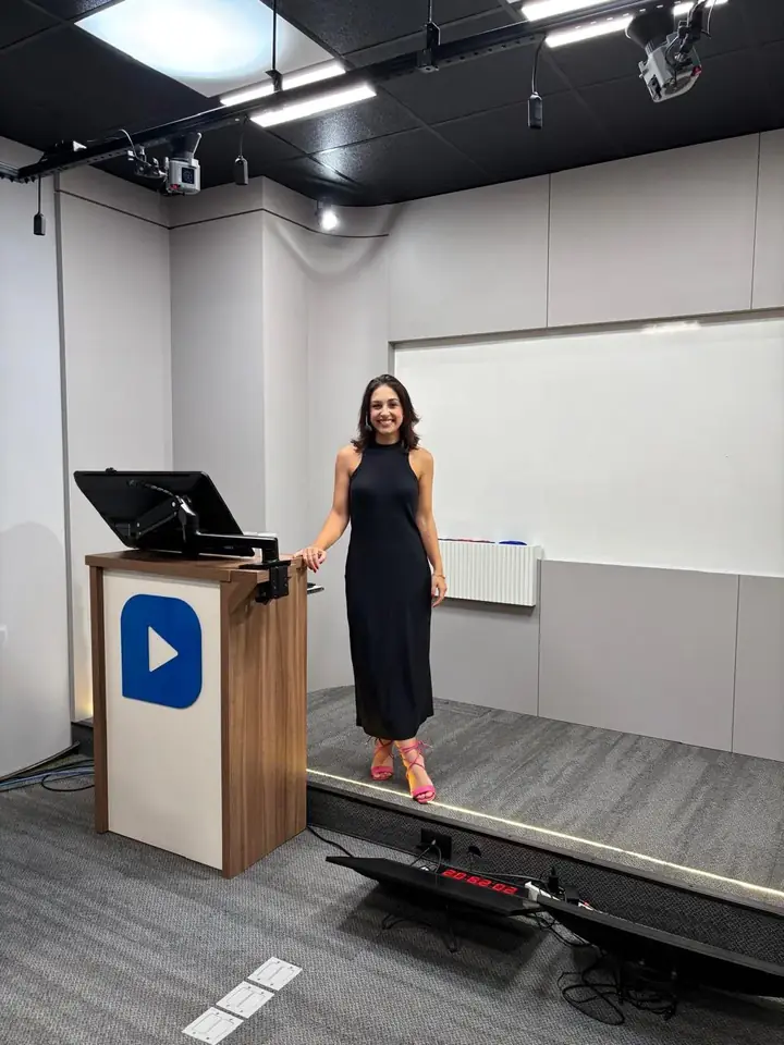 Roberta Ertel em sala de aula junto ao púlpito com a marca CEISC visível