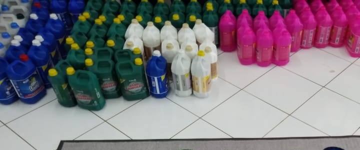 Galões e frascos de produtos de limpeza no chão da loja
