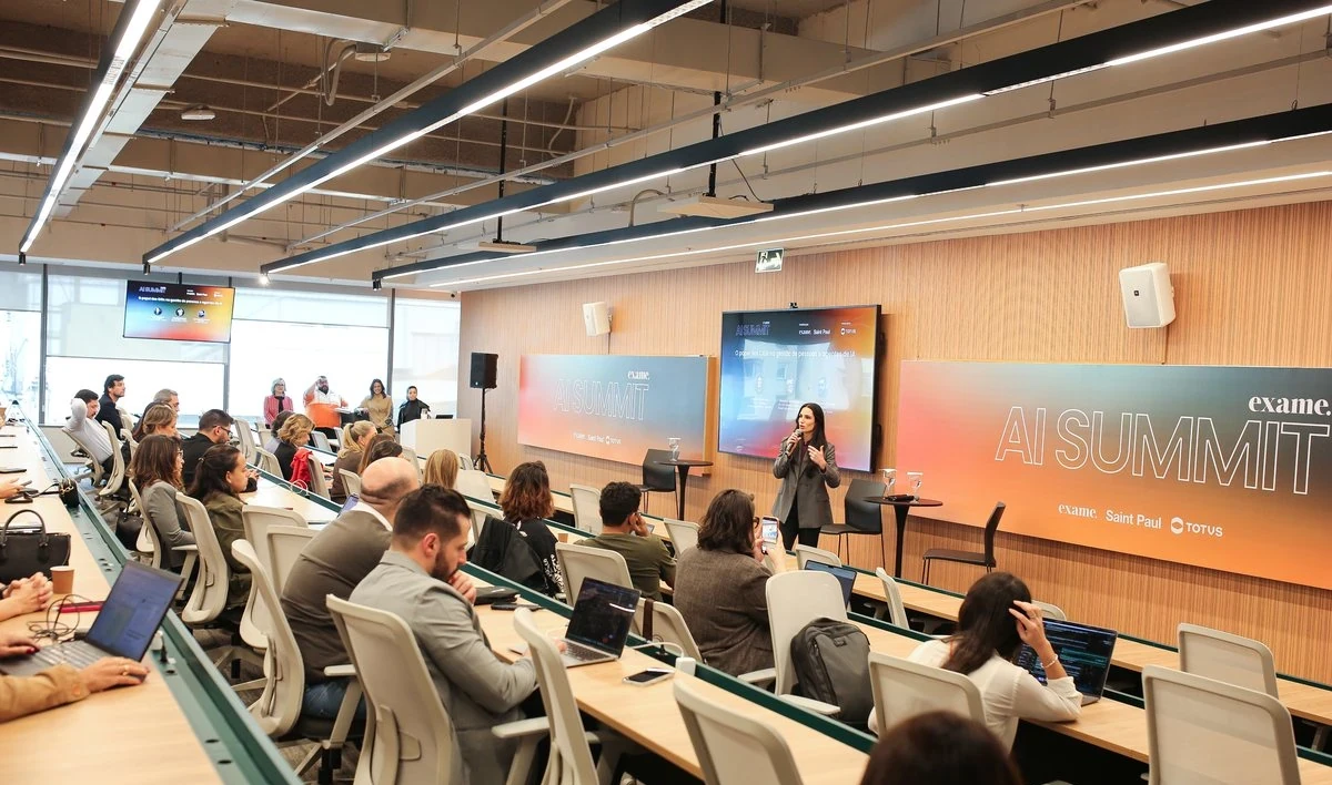 Executivos reunidos em auditório durante encontro de networking