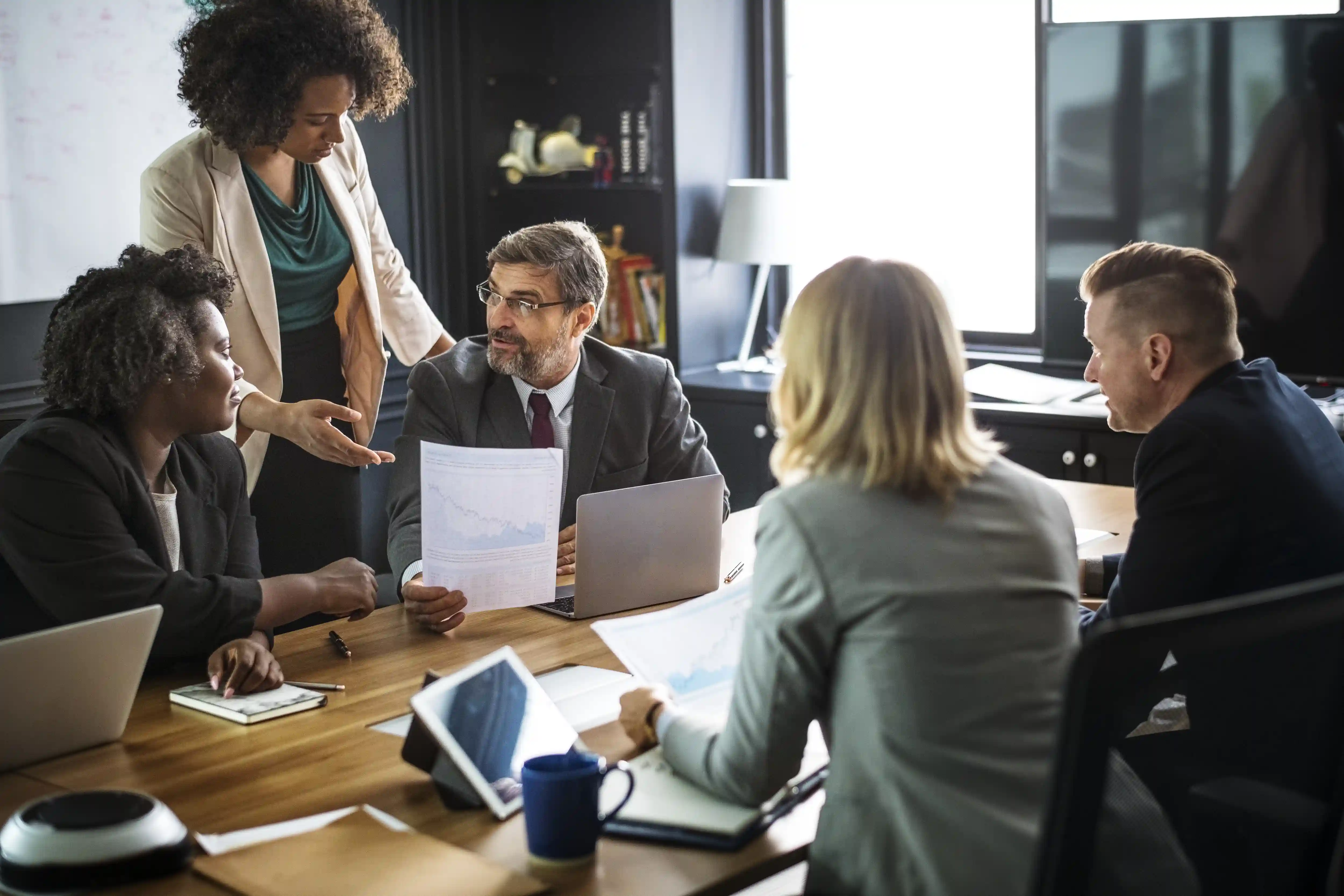 Executivos discutindo relatórios e indicadores econômicos em uma sala de reunião
