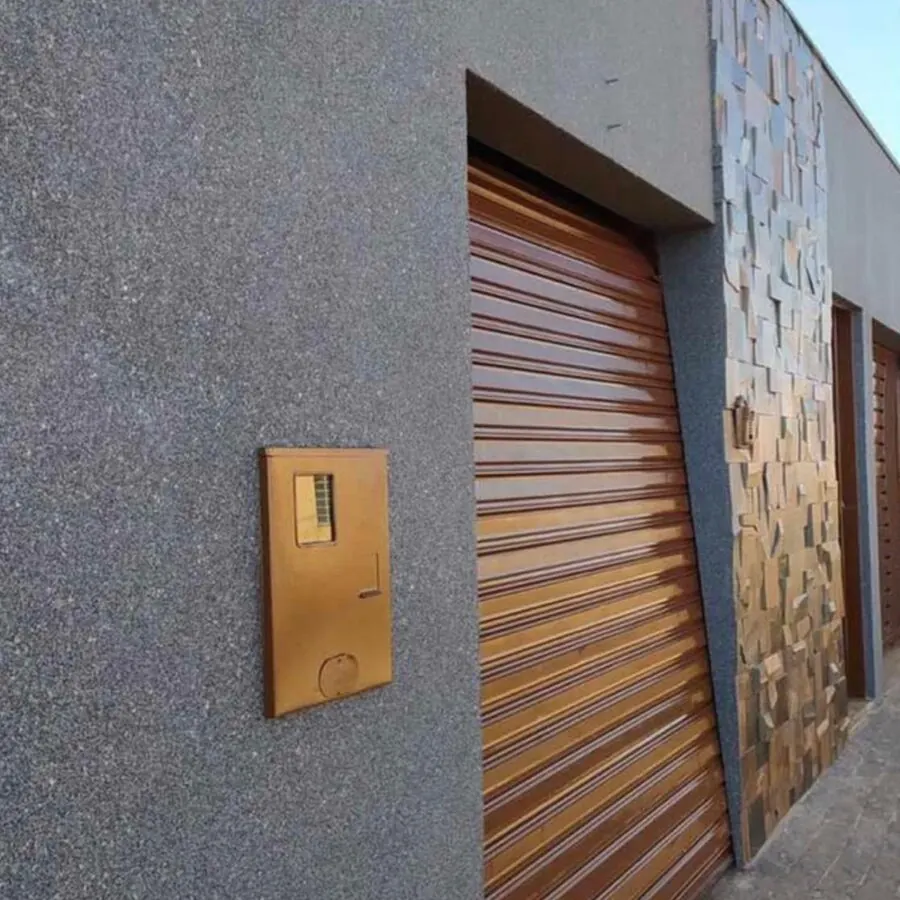 Fachada revestida em tom cinza com portão de madeira