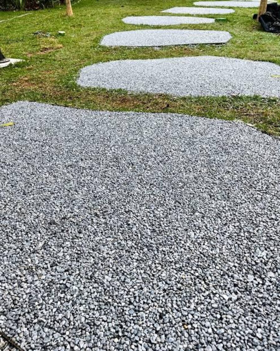 Caminho externo com piso drenante e pedras de passagem