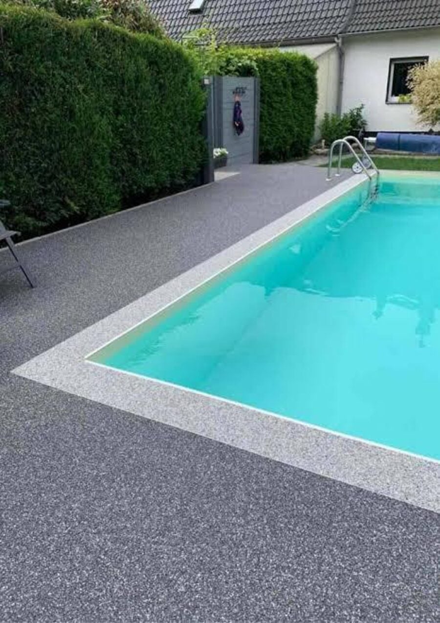 Piso drenante em tom cinza com preto ao redor de piscina