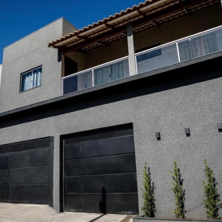 Fachada de sobrado revestida em tom preto com cinza