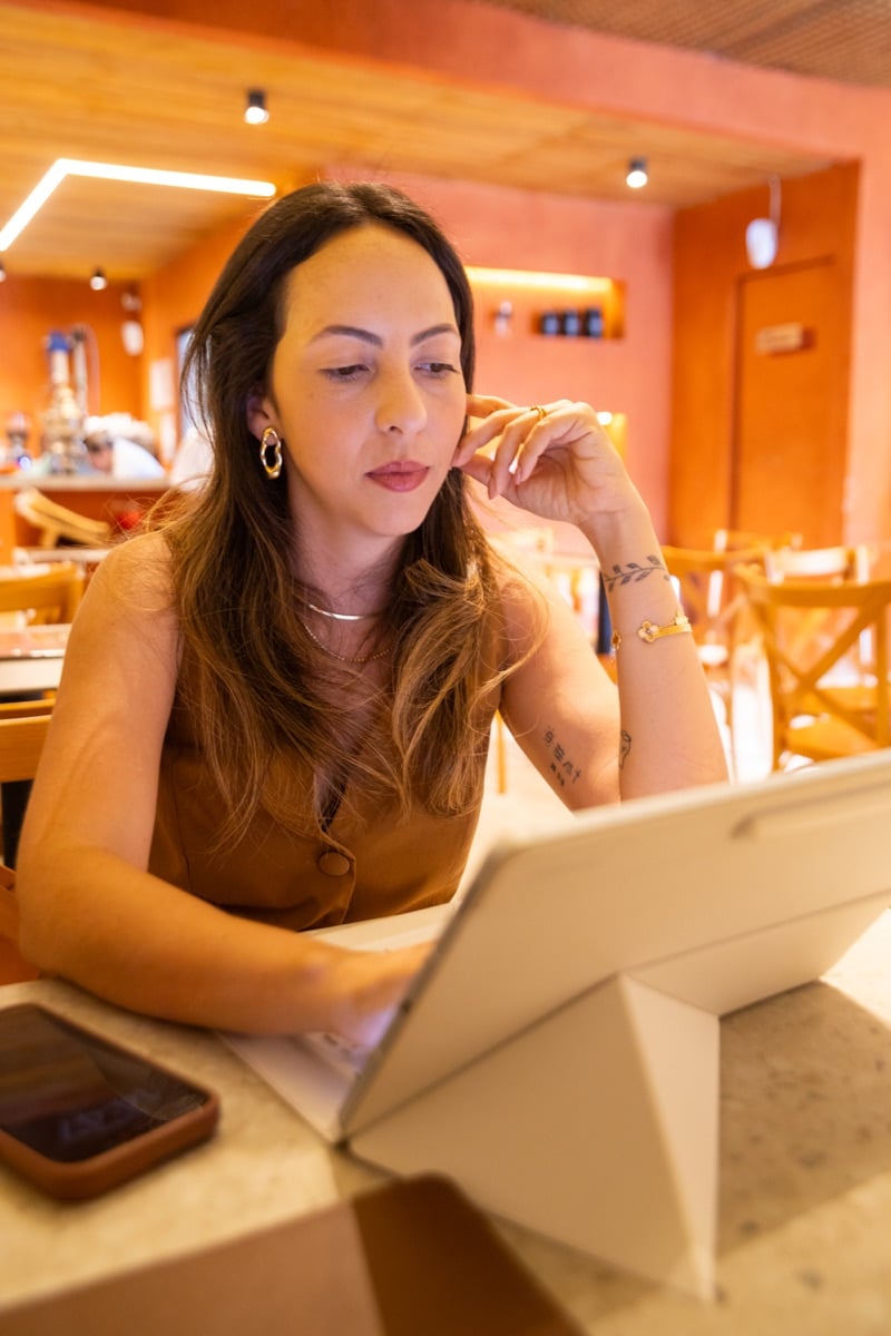 Thalia Cardoso trabalhando com um tablet.