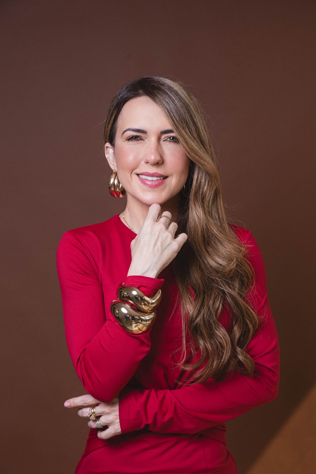 Carolina Tavares sorrindo, com roupa vermelha