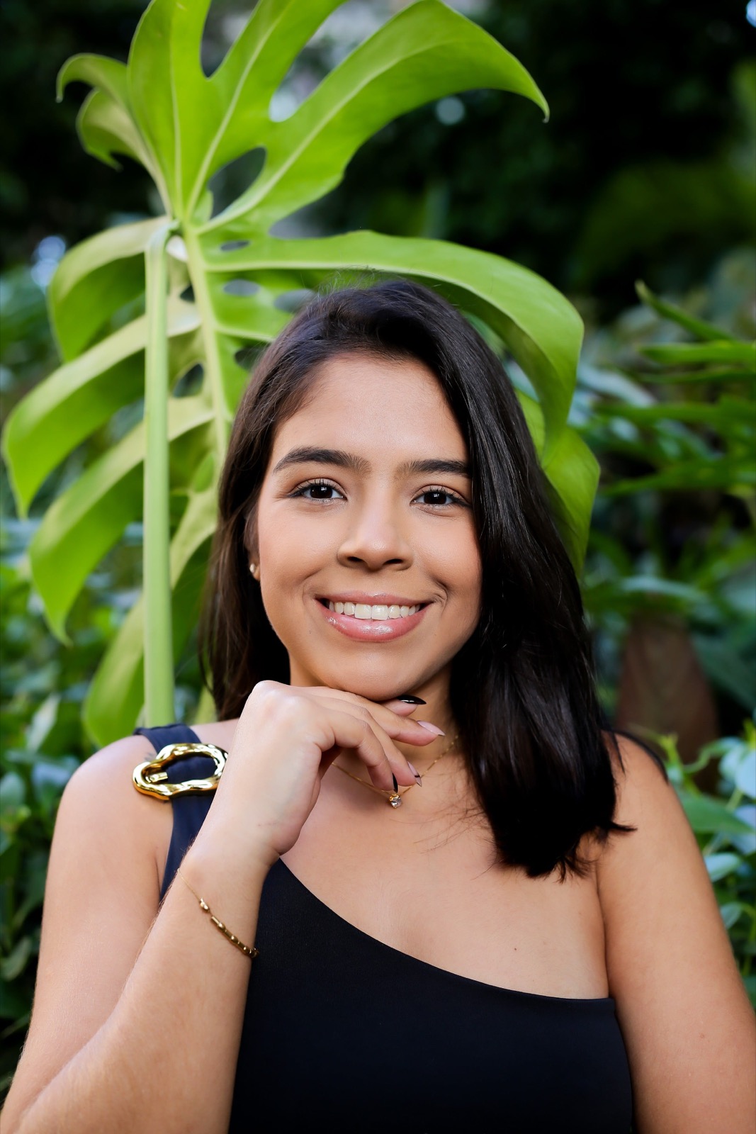 Carolina Mota sorrindo, com a mão apoiada abaixo do rosto