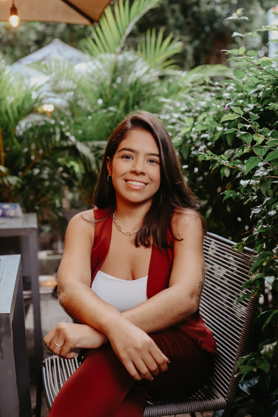 Carolina Mota sorrindo, com os braços apoiados e as mãos visíveis