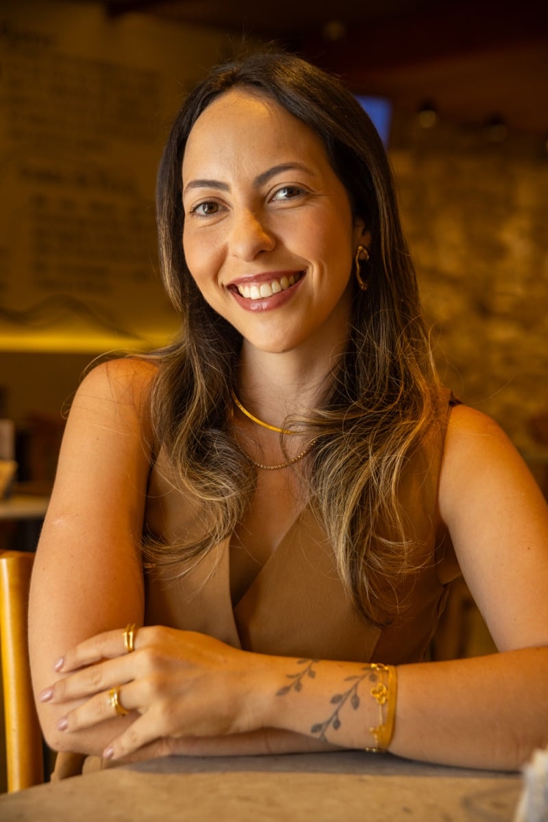 Thalia Cardoso sorrindo, com os braços apoiados.