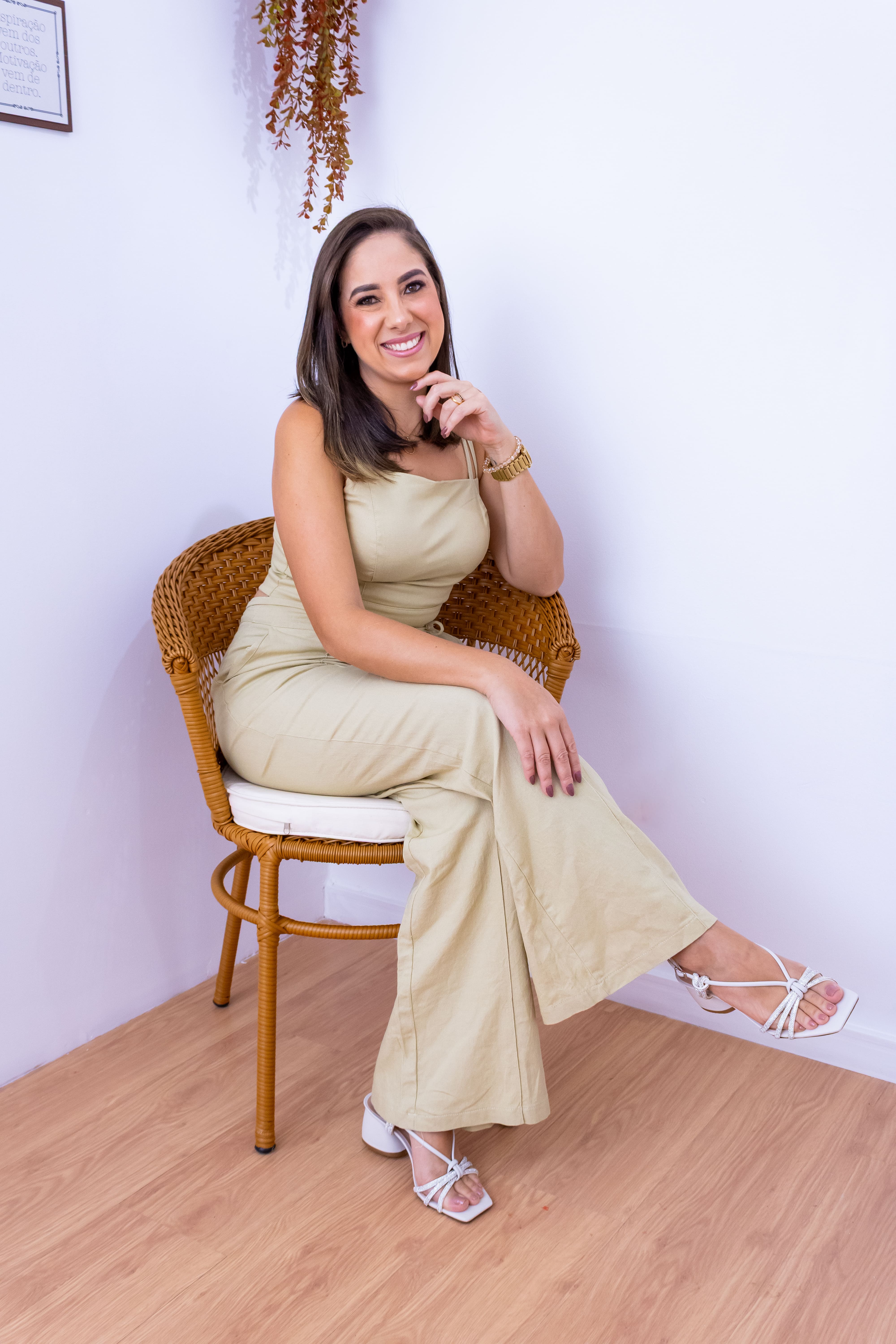 Nutricionista Priscila Machado sorrindo, sentada em uma cadeira
