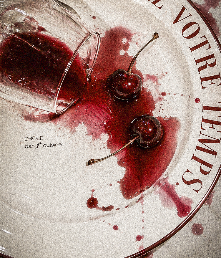 Drôle — cerejas e vinho derramado no prato