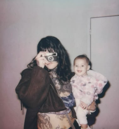 Foto pessoal de Lie Faria fotografando, segurando sua filha no colo