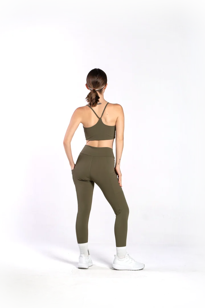 Modelo vestindo calça legging e top dupla face verde militar