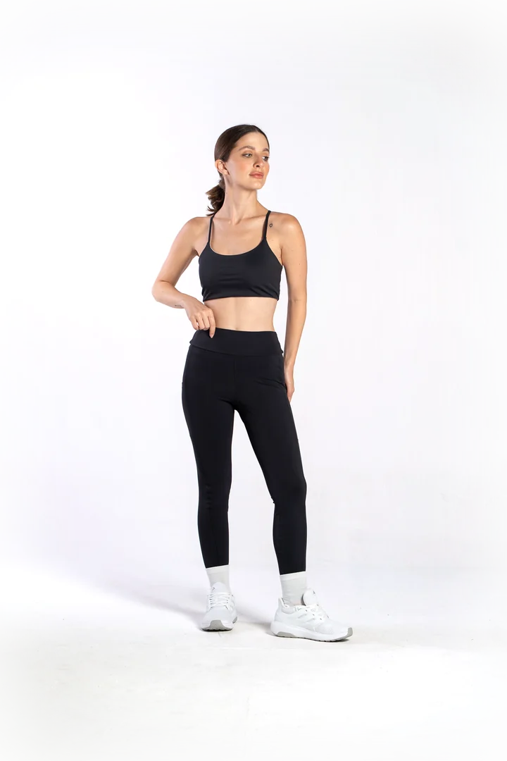 Modelo vestindo calça legging preta com bolsos