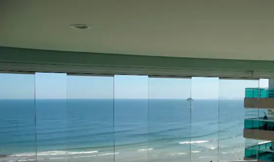Sacada fechada com vidro de frente para o mar