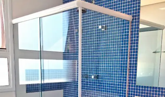 Box de vidro instalado em banheiro com pastilha azul