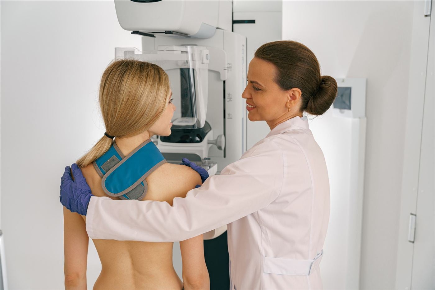 Médica realizando exame de mamografia em paciente