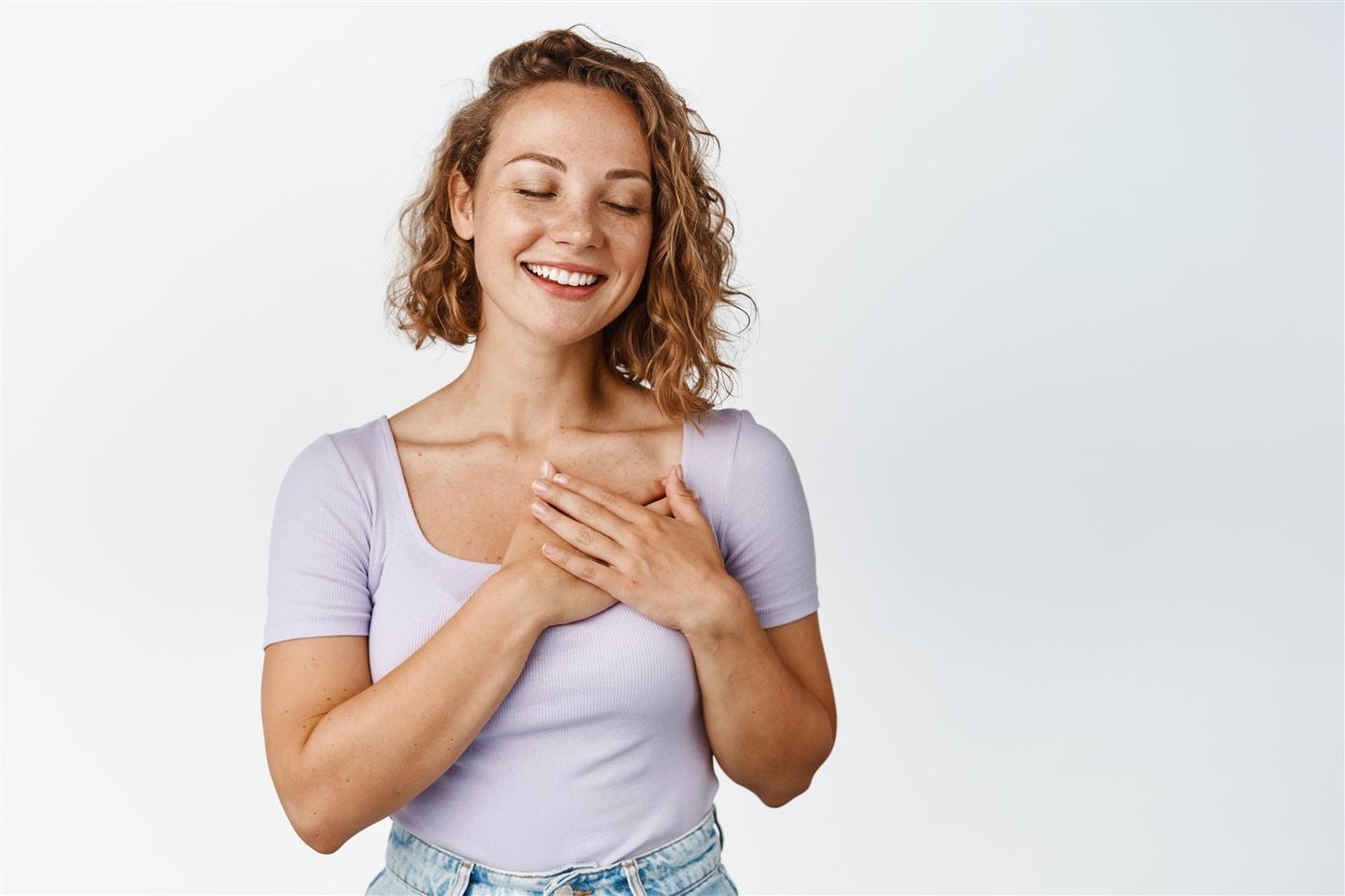 Mulher sorrindo com as mãos no peito, representando cuidado e prevenção