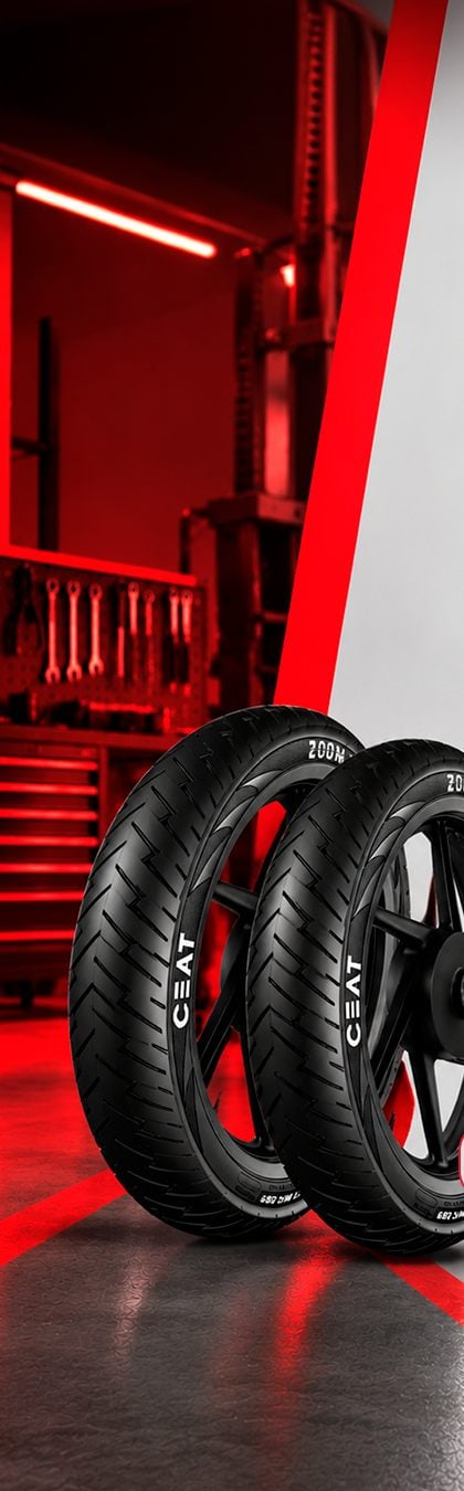 Pneus CEAT em oficina de moto, com parede de ferramentas ao fundo