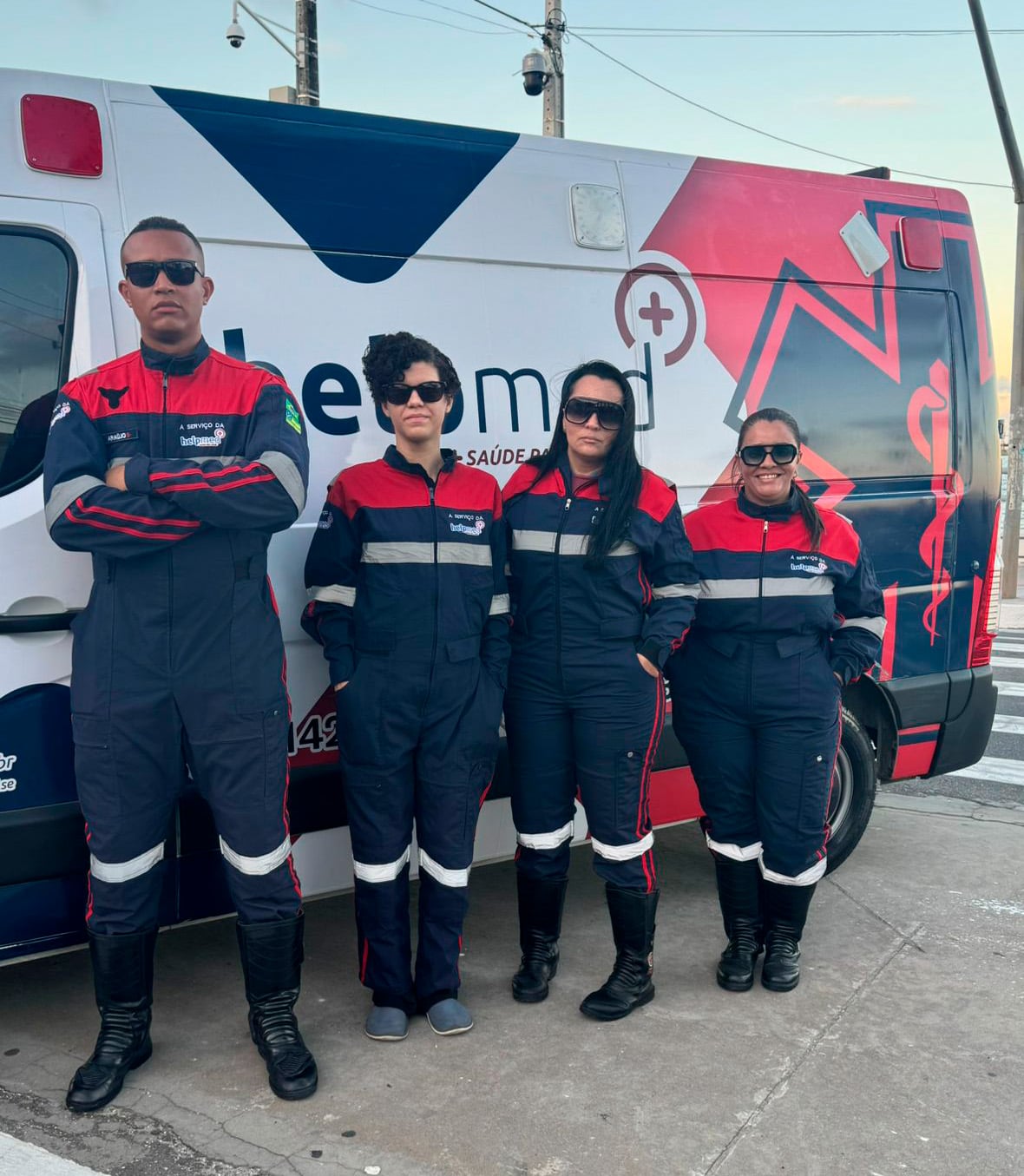 Equipe Help Med uniformizada ao lado da ambulância Help Med