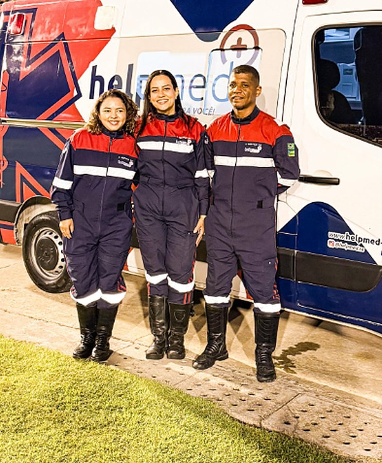 Equipe Help Med uniformizada ao lado da ambulância Help Med