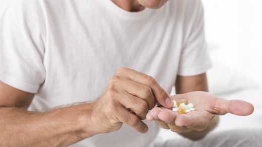 Homem com medicamentos na mão