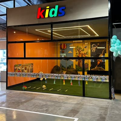 Fachada da área kids da Foren Wellness, com grama sintética e circuito montado