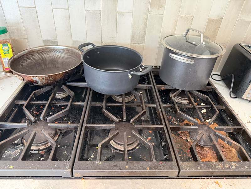 Gas stove with grease and burnt residue before cleaning