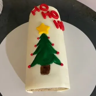 Bolo de rolo coberto com pasta branca e decorado com árvore de Natal, produção da aluna Christiane