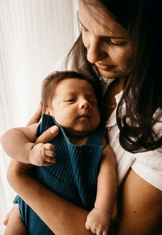 Mãe e bebê em close, com luz natural