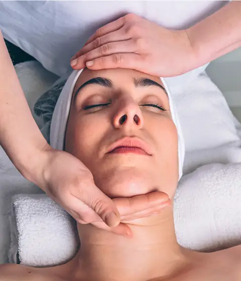 Drenagem linfática facial com a cliente deitada na maca