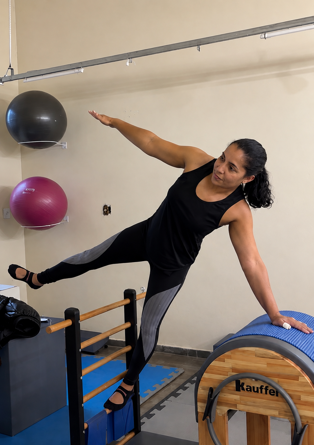 Aluna praticando alongamento lateral no ladder barrel